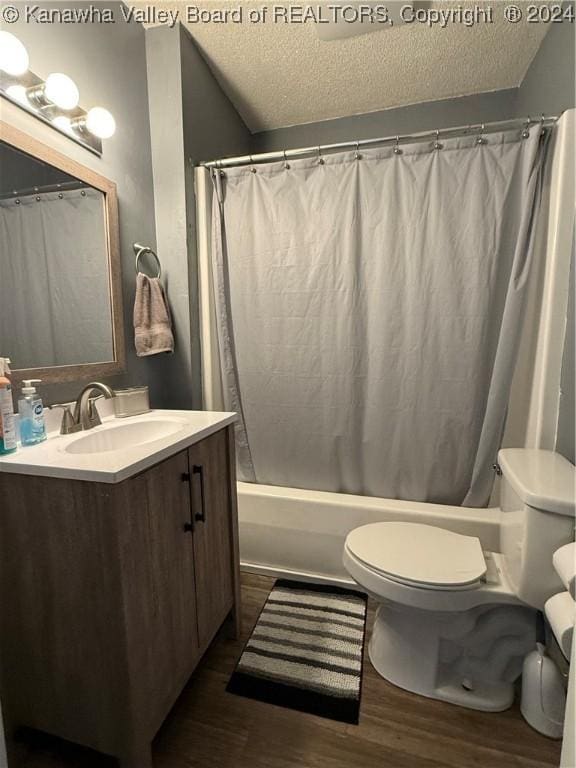 full bathroom with hardwood / wood-style floors, vanity, toilet, a textured ceiling, and shower / tub combo with curtain