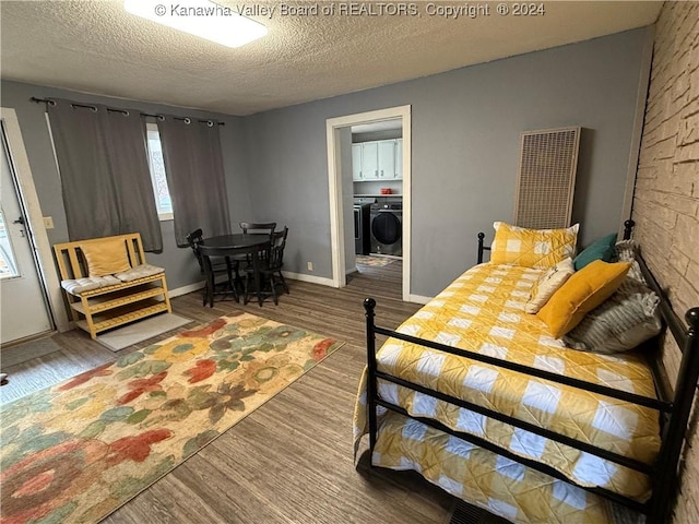 bedroom with wood-type flooring, a textured ceiling, and washer and clothes dryer