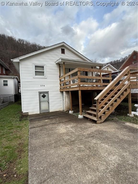 rear view of house featuring a wooden deck