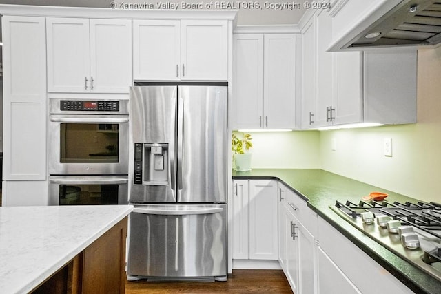 kitchen with white cabinetry, range hood, and appliances with stainless steel finishes