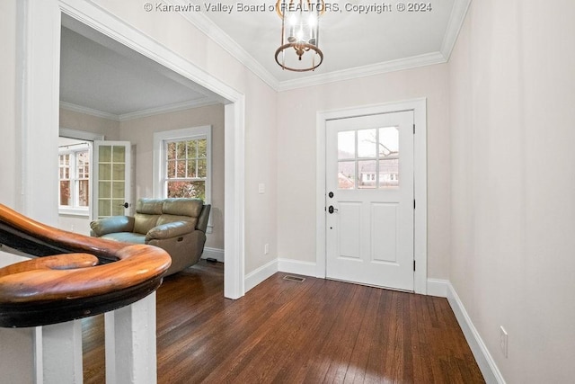 foyer with dark wood-type flooring, crown molding, a healthy amount of sunlight, and a notable chandelier