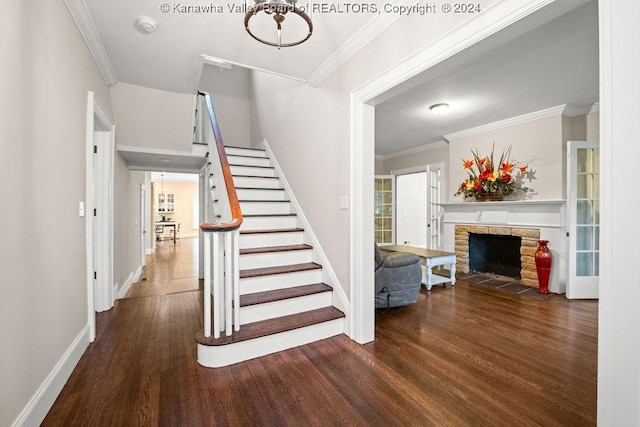 stairway with a fireplace, ornamental molding, and hardwood / wood-style flooring