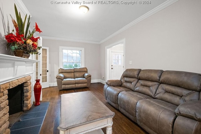 living room with dark hardwood / wood-style floors, a stone fireplace, and ornamental molding