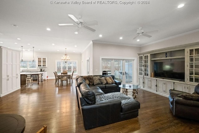 living room with dark hardwood / wood-style flooring, ceiling fan with notable chandelier, and ornamental molding