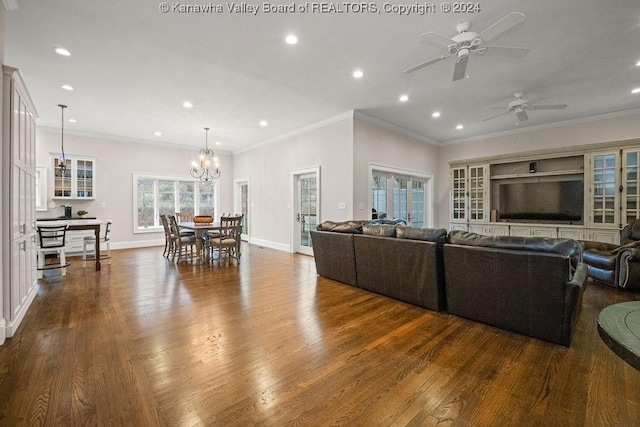 living room featuring hardwood / wood-style flooring, ceiling fan with notable chandelier, and crown molding