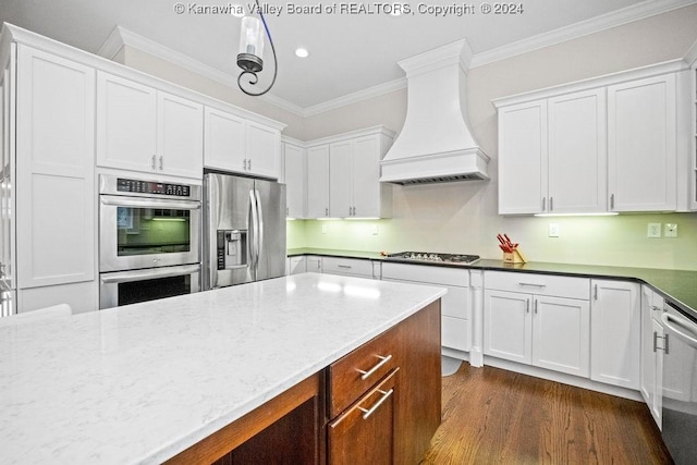 kitchen with premium range hood, stainless steel appliances, crown molding, dark wood-type flooring, and white cabinets