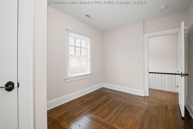 unfurnished room with dark parquet flooring