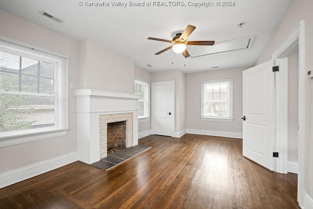 unfurnished living room with ceiling fan, dark wood-type flooring, and a tiled fireplace