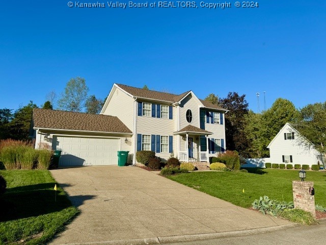 colonial home with a front yard and a garage