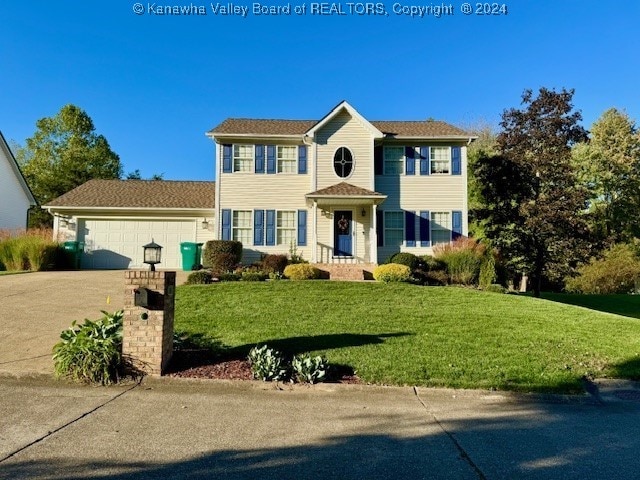 colonial-style house featuring a garage and a front lawn