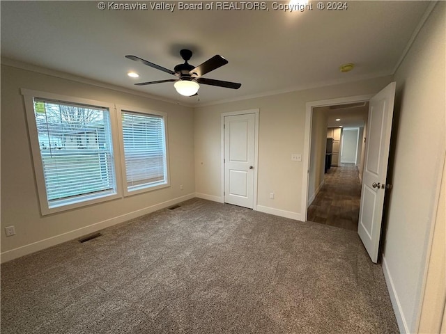 unfurnished bedroom featuring ceiling fan, carpet floors, and crown molding