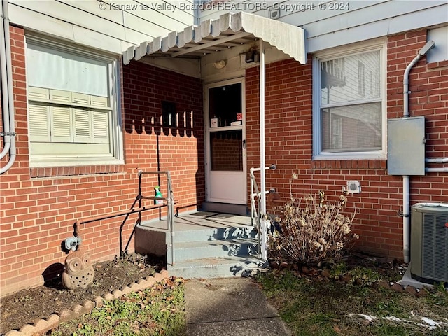 view of exterior entry featuring central air condition unit