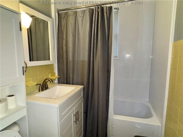 bathroom with vanity, decorative backsplash, shower / bathtub combination with curtain, and tile walls