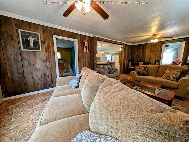 living room with ornamental molding and wood walls