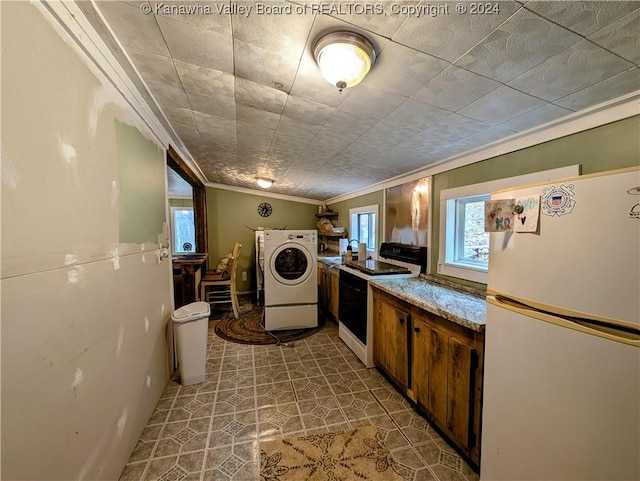 kitchen featuring light stone counters, tile patterned flooring, white appliances, washer / dryer, and ornamental molding