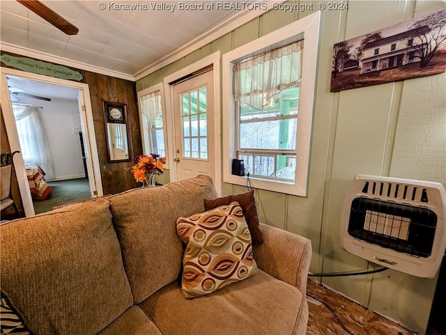 living area featuring ceiling fan, ornamental molding, and heating unit