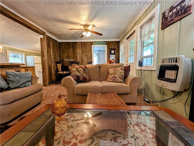 living room with heating unit, crown molding, ceiling fan, and wood walls