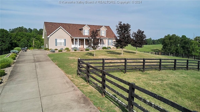 cape cod home with a rural view and a front lawn