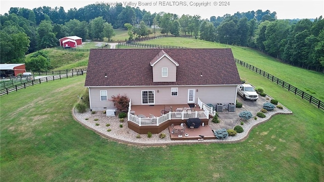 rear view of property featuring a yard, a rural view, and central AC unit