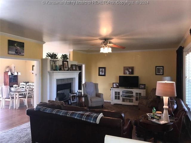 living room featuring hardwood / wood-style floors, ceiling fan, and crown molding