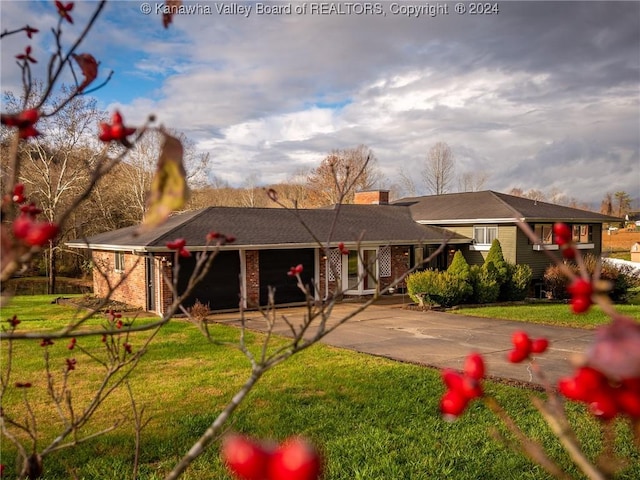 view of front of property featuring a front yard and a garage