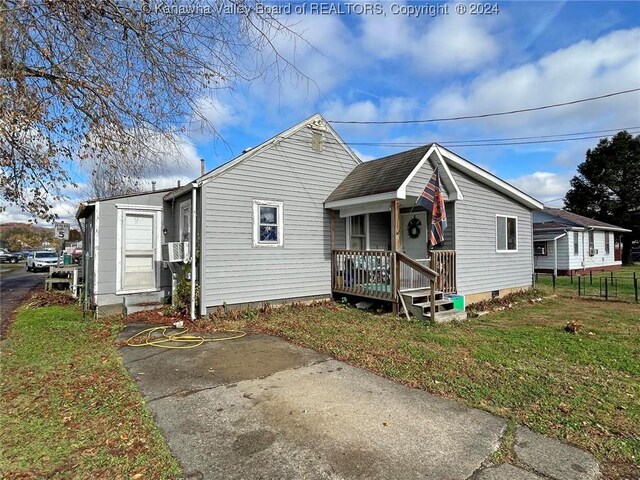 bungalow-style home featuring cooling unit and a front yard