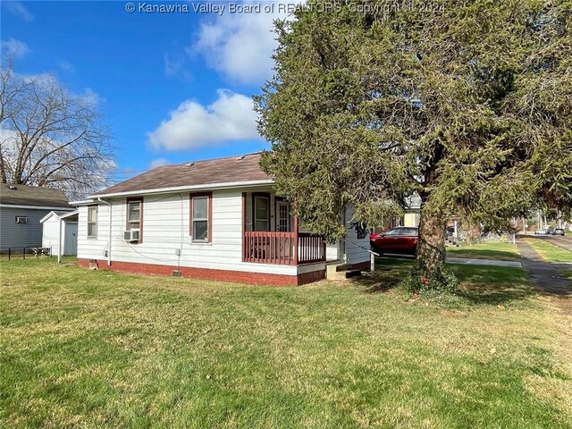 exterior space featuring cooling unit, covered porch, and a yard