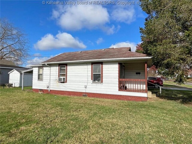 view of side of home with a yard, cooling unit, and covered porch