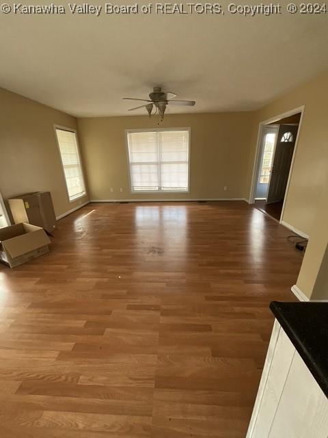 unfurnished living room with ceiling fan and hardwood / wood-style flooring