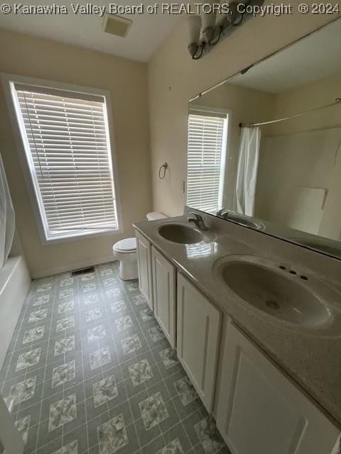 full bathroom with shower / bath combo, vanity, and toilet