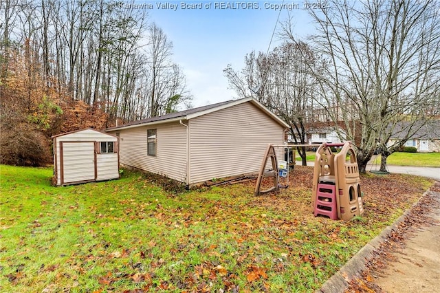 view of side of home featuring a yard, a playground, and a shed