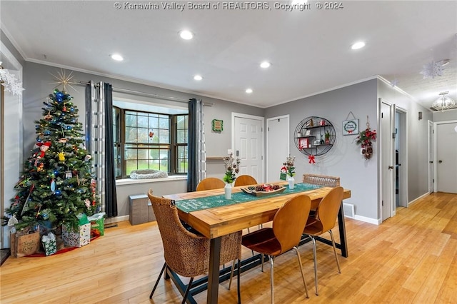 dining space featuring a chandelier, light hardwood / wood-style flooring, and crown molding