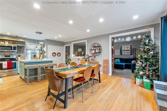 dining room featuring crown molding and light hardwood / wood-style floors