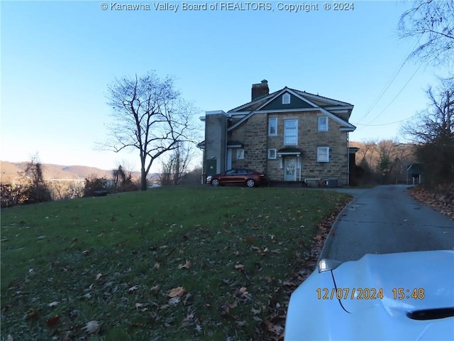 view of front of home with a mountain view and a front lawn