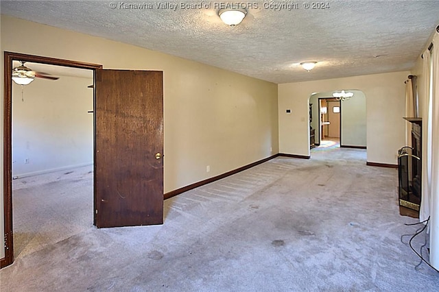 carpeted spare room featuring ceiling fan and a textured ceiling