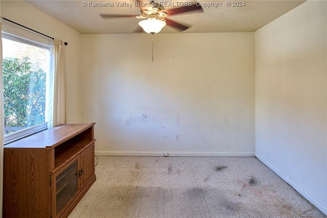 carpeted spare room featuring ceiling fan