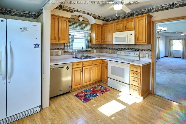 kitchen with white appliances, light hardwood / wood-style floors, plenty of natural light, and sink