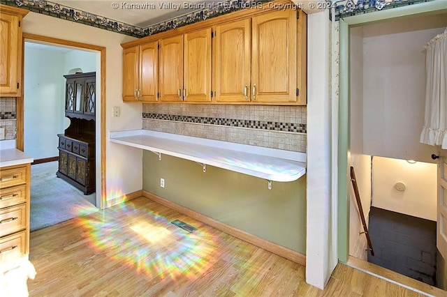 kitchen featuring tasteful backsplash and light hardwood / wood-style floors