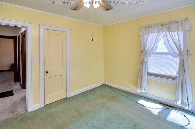 carpeted empty room featuring crown molding and ceiling fan