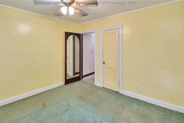 carpeted spare room featuring ceiling fan and ornamental molding