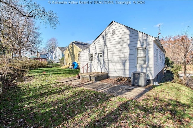 rear view of house featuring a yard and central AC unit