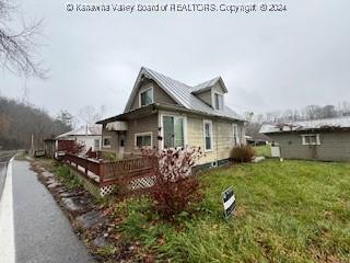 back of property with a lawn and a wooden deck