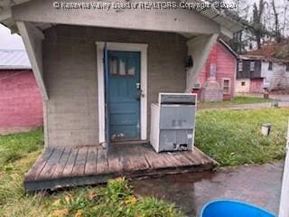 doorway to property featuring a lawn