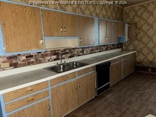 kitchen featuring dark hardwood / wood-style flooring, dishwasher, and sink