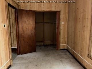 interior space with a closet and wooden walls