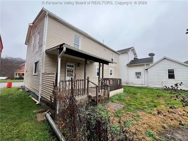 rear view of property featuring a lawn