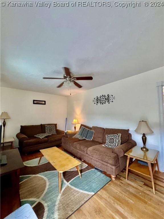 living room featuring wood-type flooring and ceiling fan