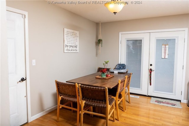 dining room with french doors and light hardwood / wood-style flooring