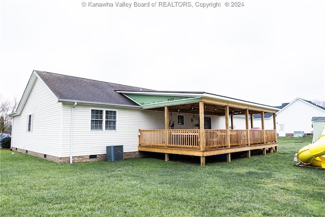 back of house with a lawn, a wooden deck, and central AC unit