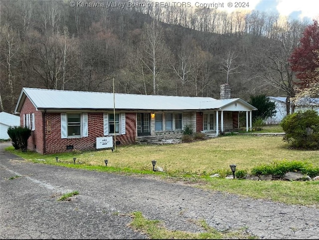 single story home featuring covered porch and a front yard